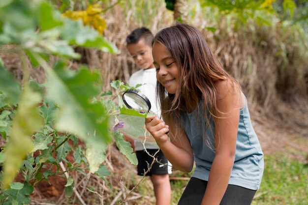 Girl using a magnifying glass while searching in a treasure hunt