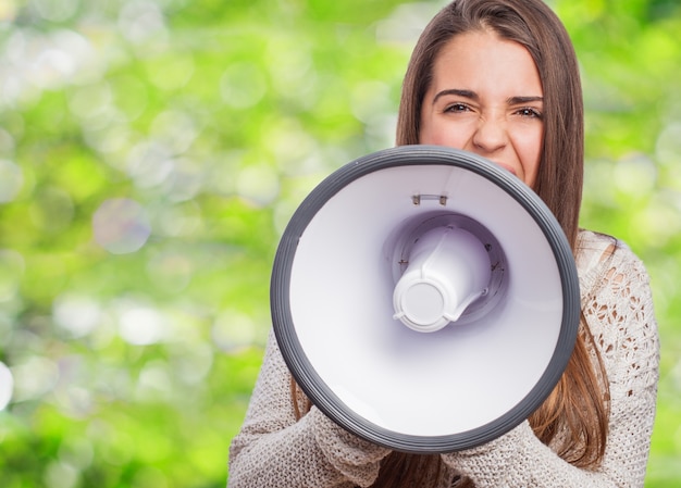 Foto gratuita ragazza utilizzando un megafono con sfondo sfocato