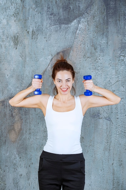 Girl using purple aerobic pilates dumbbels for arm muscles. 