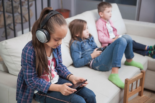 Girl using smartphone near siblings