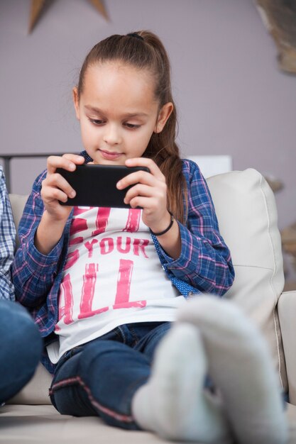 Girl using smartphone on sofa