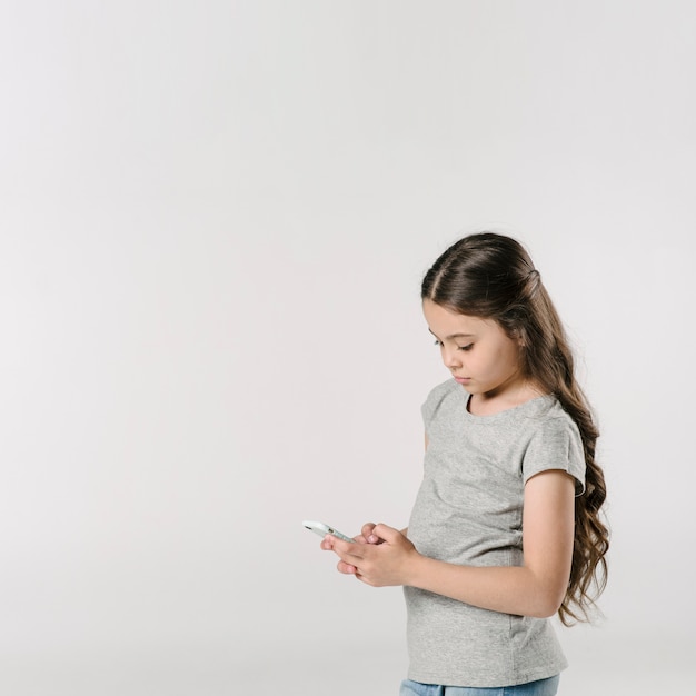 Free photo girl using smartphone in studio