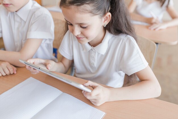 Девушка, использующая планшет во время урока