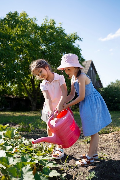 Girl using watering can outdoors in nature