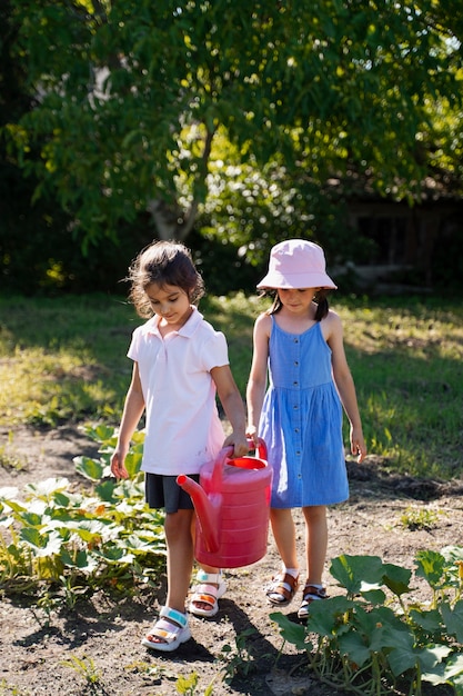 Girl using watering can outdoors in nature
