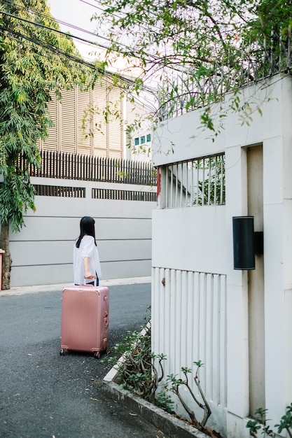 девушка гуляет с розовым багажом