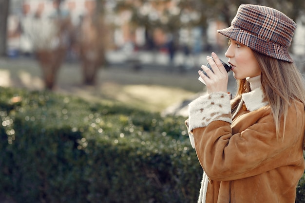 Free photo girl walking in a spring city and taking coffee