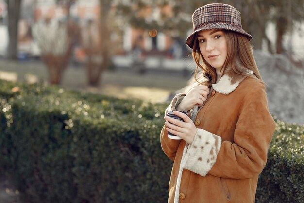 Foto gratuita ragazza che cammina in una città di primavera e prendendo caffè