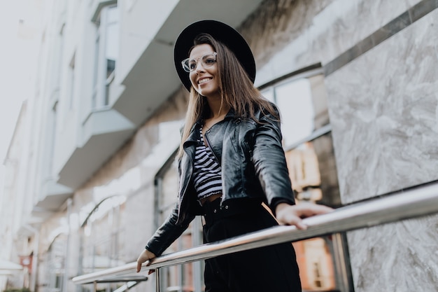 Girl walks in the city after rain near brilliant shop windows in cold weather in the day