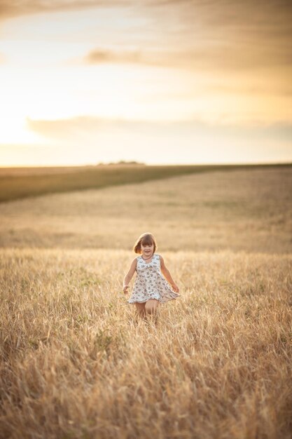 Girl walks in field with rye at sunset lifestyle