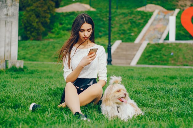 The girl walks in the park with her dog