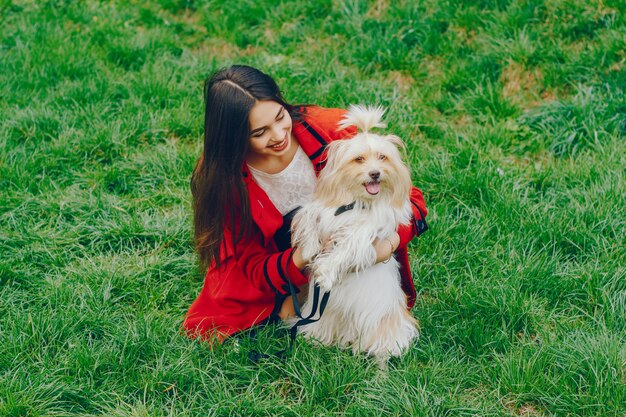 The girl walks in the park with her dog