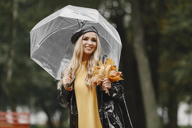 Girl walks. Woman in a black coat. Blonde with a black cap. Lady with umbrella.