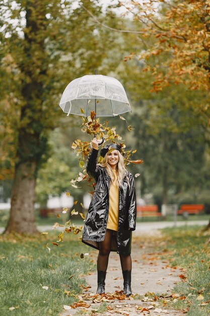 Girl walks. Woman in a black coat. Blonde with a black cap. Lady with umbrella.