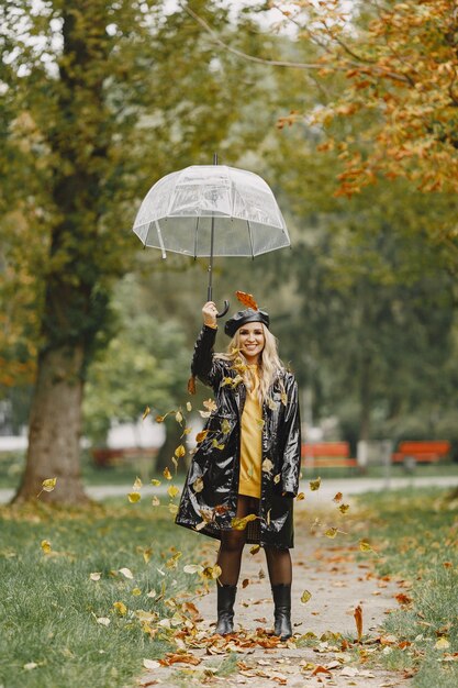 Girl walks. Woman in a black coat. Blonde with a black cap. Lady with umbrella.