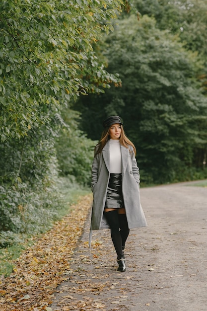 Girl walks. Woman in a gray coat. Brunette with a black cap.