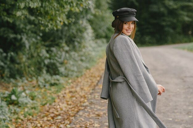 Girl walks. Woman in a gray coat. Brunette with a black cap.