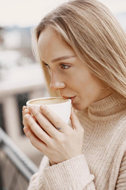 暖かい薄手のコートを着た女の子。山での休暇。長い髪の女性。