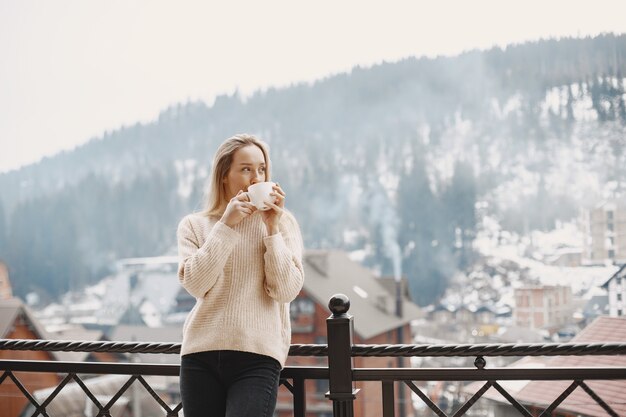 暖かい薄手のコートを着た女の子。山での休暇。長い髪の女性。