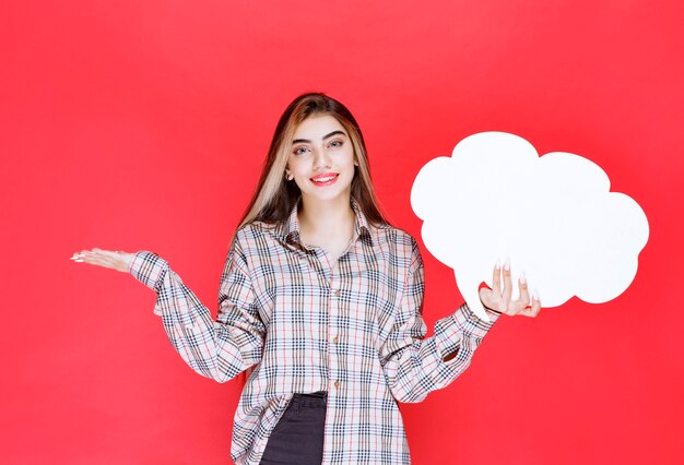 Girl in warm sweater holding a cloud shape ideaboard and presenting the challenge