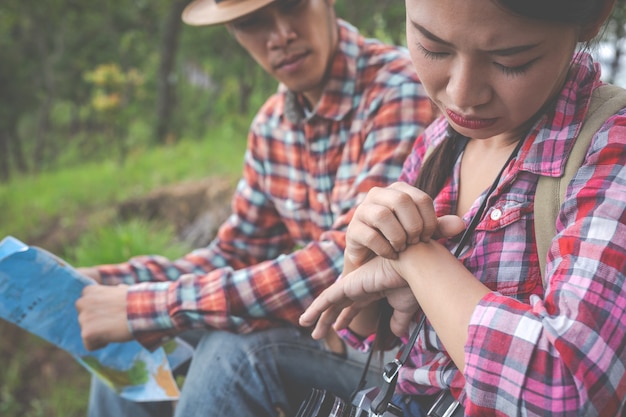 The girl was bitten by an insect on the back of the hand on a hill in a tropical forest, hiking, traveling, climbing.