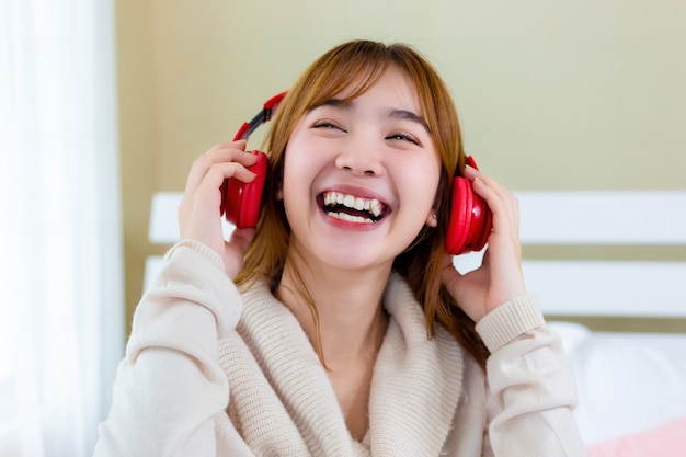 Free photo the girl was wearing headphones nd enjoying music on the bed