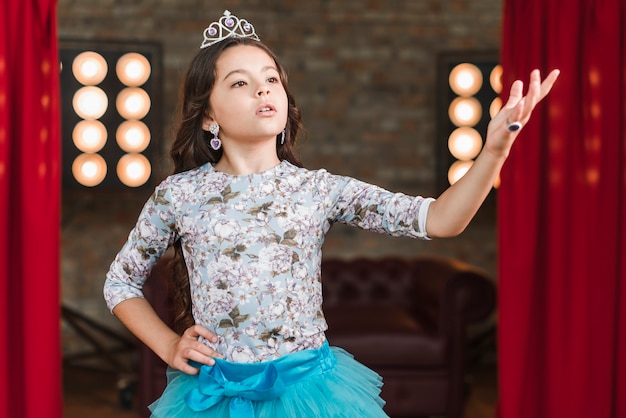 Girl wearing crown performing on stage