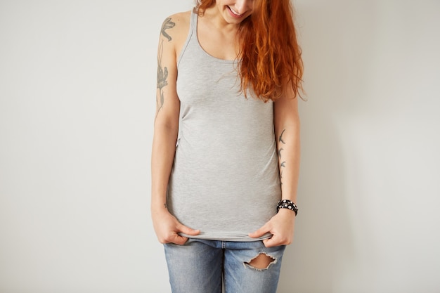 Free photo girl wearing grey blank t-shirt standing on white wall