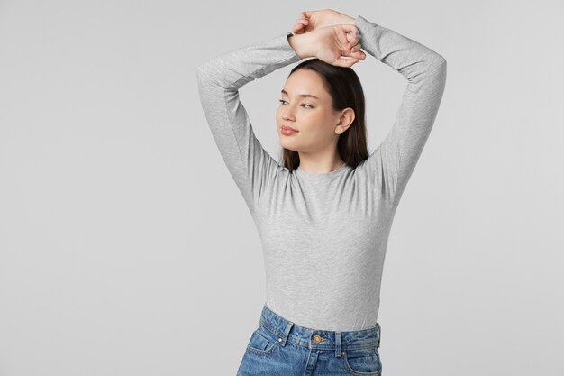 Girl wearing grey t-shirt posing in studio