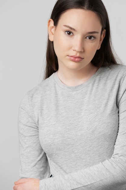 Girl wearing grey t-shirt posing in studio