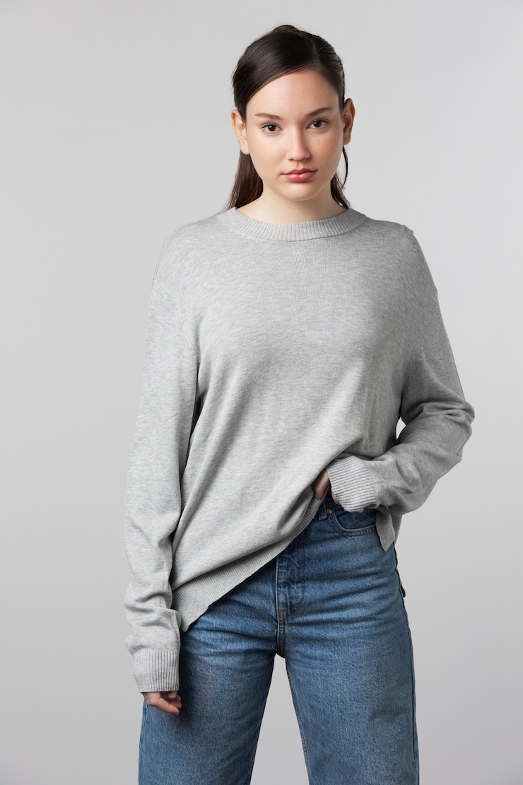 無料Photo スタジオでポーズをとって灰色のtシャツを着ている女の子