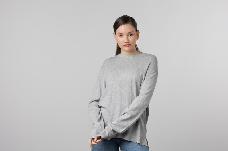 無料Photo スタジオでポーズをとって灰色のtシャツを着ている女の子