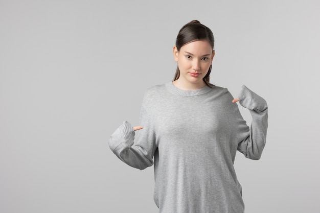 Free photo girl wearing grey t-shirt posing in studio