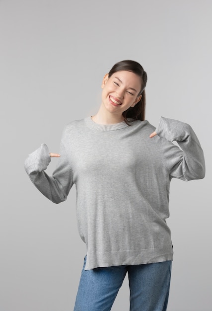 Girl wearing grey t-shirt posing in studio