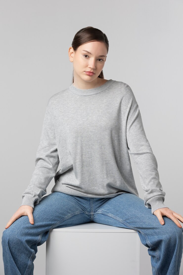 無料Photo スタジオでポーズをとって灰色のtシャツを着ている女の子