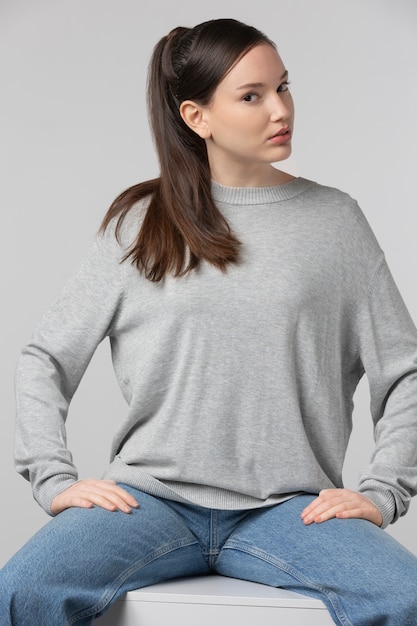 Girl wearing grey t-shirt posing in studio