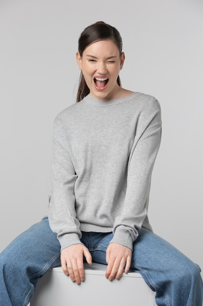 Girl wearing grey t-shirt posing in studio