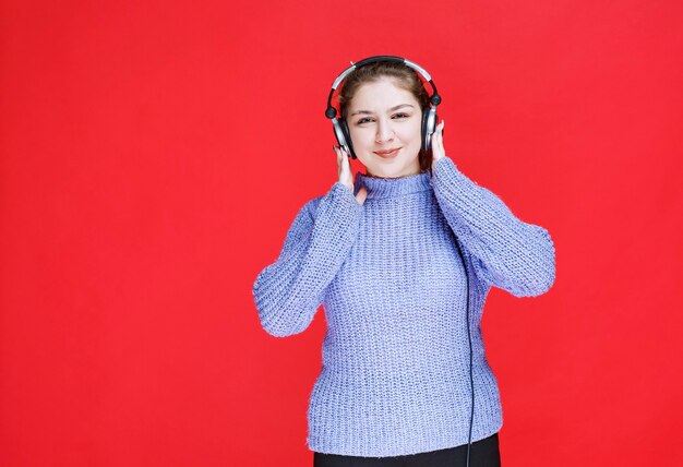 Girl wearing her headphones to listen to the music.