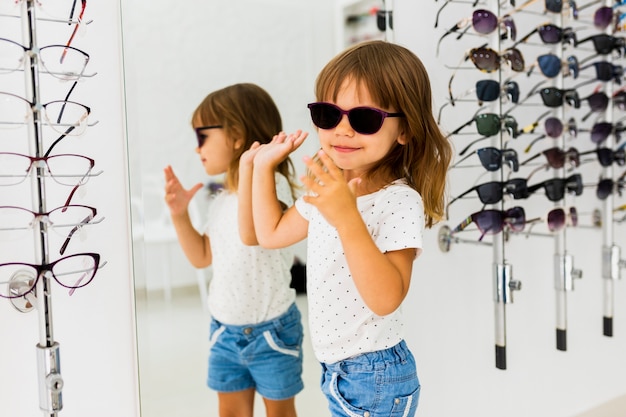 Ragazza che indossa occhiali da sole in negozio