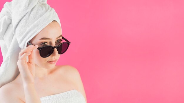 Девушка в полотенце и солнцезащитные очки копией пространства