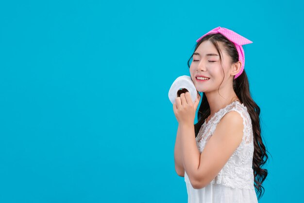 Girl wearing white pajamas Holding a rolltissue paper in the hand on the blue .