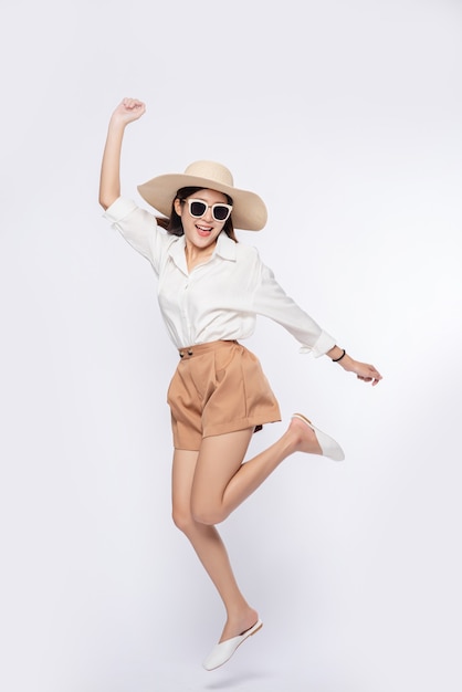 Girl wearing a white shirt and shorts wearing a hat Wear glasses and handle on the hat