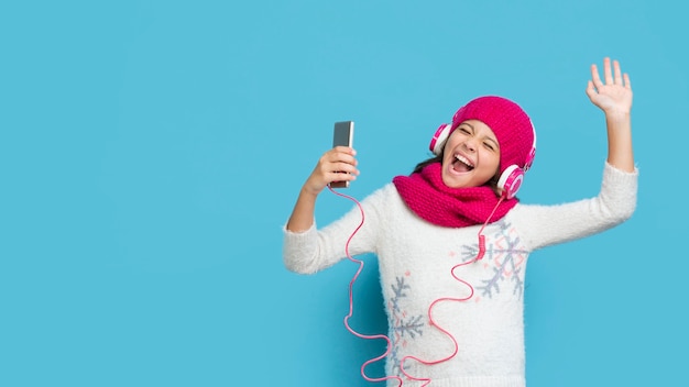 Free photo girl wearing winter clothes listening music