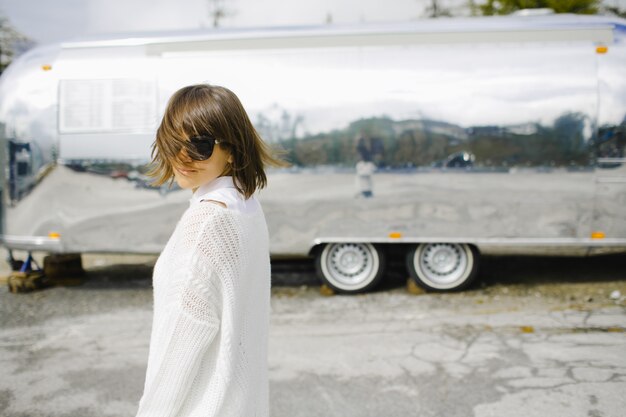 Girl in white clothes near to the luxury vehicle