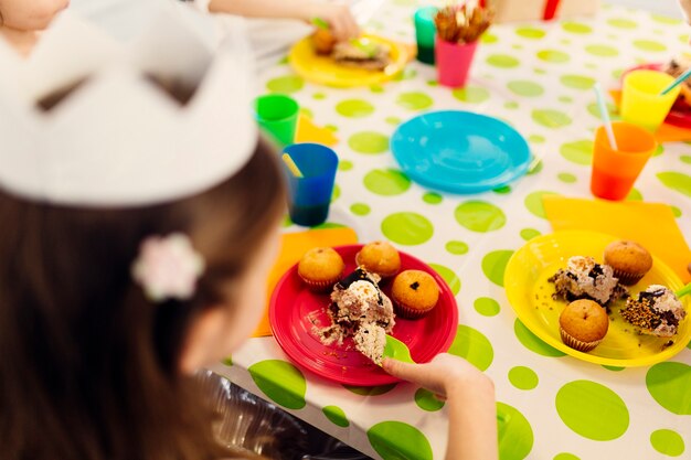 Girl in white paper crown at table 