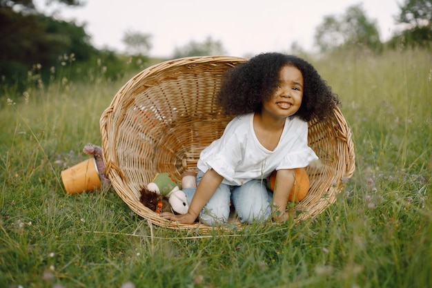 Girl in wicker basket with balloons in sunlight in summer time