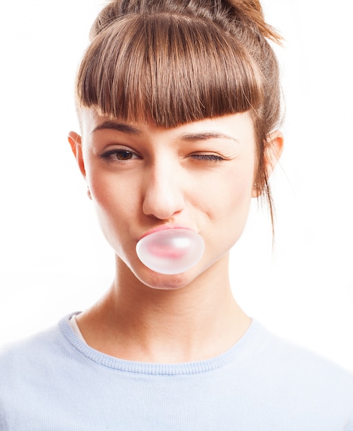 Girl winking and making a bubble with a gum