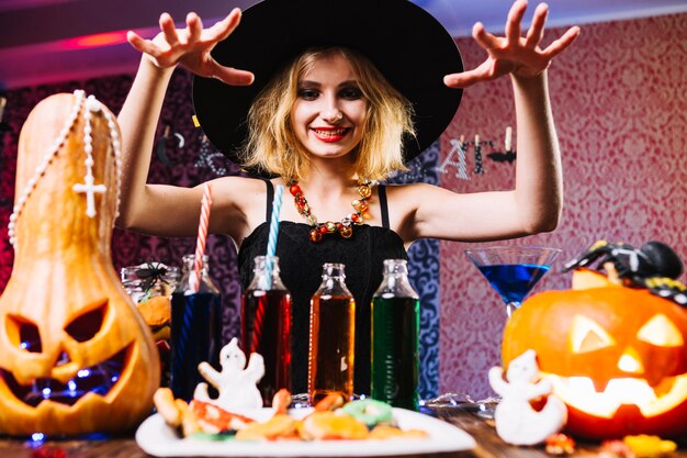 Girl in witch hat over table