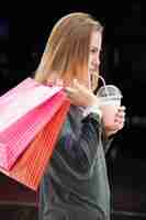 Бесплатное фото Девушка со стаканом и сумки на покупку