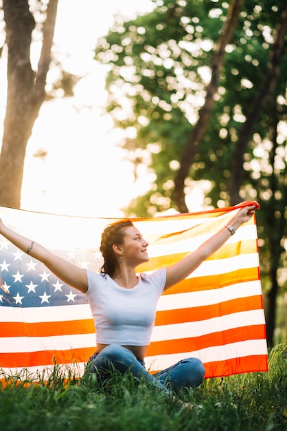 自然のアメリカの旗を持つ女の子